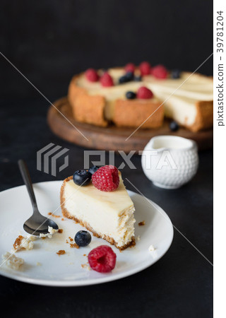 Slice of cheesecake with missing bite on white Slice of cheesecake with missing bite on white 39781204