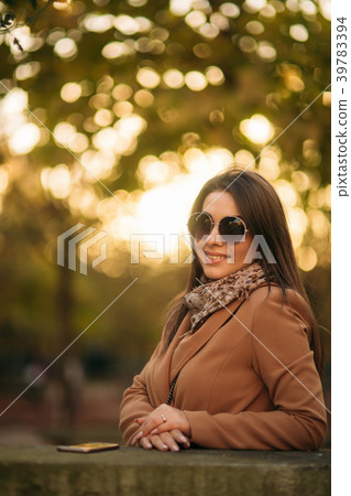 Stylish girl in a brown coat and a scarf with Stylish girl in a brown coat and a scarf with 39783394