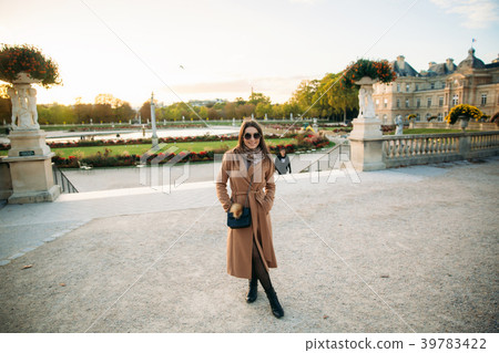 Stylish girl in coat posing for photographer. Park Stylish girl in coat posing for photographer. Park 39783422