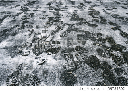 Footprints of the people in the snow on asphalt in Footprints of the people in the snow on asphalt in 39783802