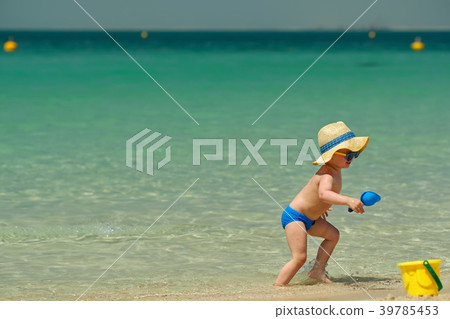 Two year old toddler playing on beach Two year old toddler playing on beach 39785453
