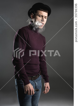 Discontented young male exhausting smoke 39786396