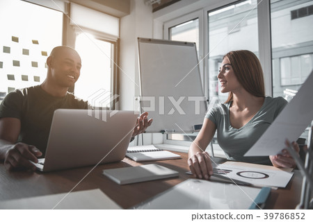 Glad man and woman discussing project in 39786852