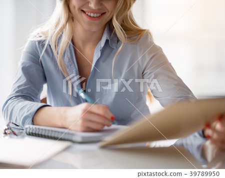 Positive woman signing an agreement at workplace Positive woman signing an agreement at workplace 39789950