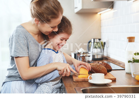preparation of family breakfast. mother and child daughter cut b preparation of family breakfast. mother and child daughter cut b 39790331