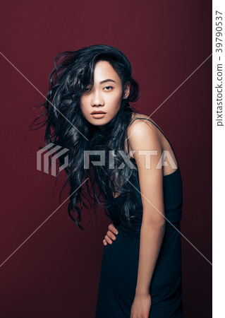 Beautiful asian woman in black dress posing in studio 39790537