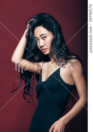 Beautiful asian woman in black dress posing in studio 39790579