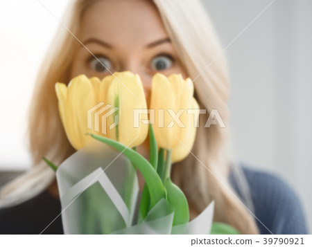 Surprised woman holding bouquet with excitement Surprised woman holding bouquet with excitement 39790921