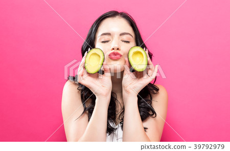 Young woman holding an avocado 39792979