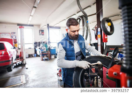 Man mechanic repairing a car in a garage. 39793257
