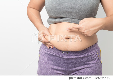 Overweight woman hand pinching excessive belly fat 39793549