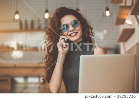 Joyful woman talking on mobile phone in coffee 39793730