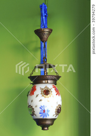 Vintage lamp hanging on green wall. 39794279