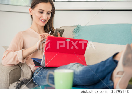 Creative woman sitting on sofa while working on 39795158