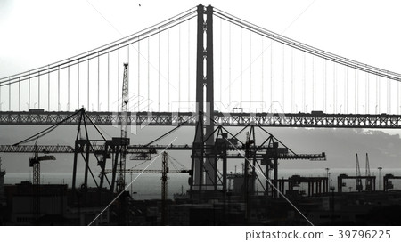 Suspension bridge, port and cranes backlit Suspension bridge, port and cranes backlit 39796225