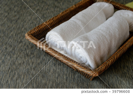 White rolled towels in wicker basket White rolled towels in wicker basket 39796608
