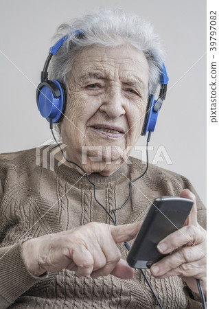 Senior woman listening music with headphones Senior woman listening music with headphones 39797082
