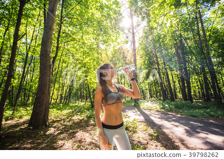 Sporty woman drinking water outdoor on sunny day. Sporty woman drinking water outdoor on sunny day. 39798262