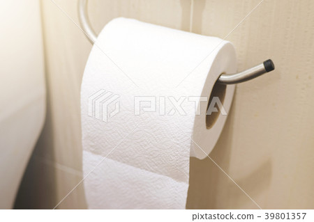 Bathroom tissue hanging on the wall. 39801357