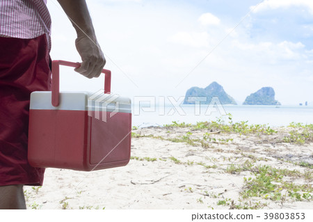 Hand of man red Ice box with background the beach  Hand of man red Ice box with background the beach  39803853