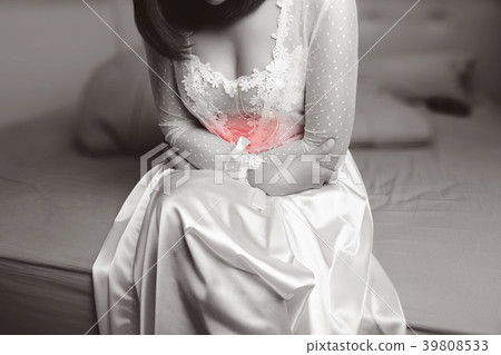 Woman in nightwear suffering from abdominal pain Woman in nightwear suffering from abdominal pain 39808533