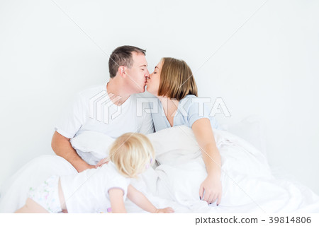 Kissing parents in sleepwear and backview daughter Kissing parents in sleepwear and backview daughter 39814806
