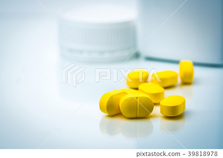 Pile of yellow tablets pills on blurred background 39818978