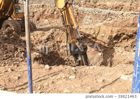 Excavator with a jackhammer breaks rocks in the 39821463