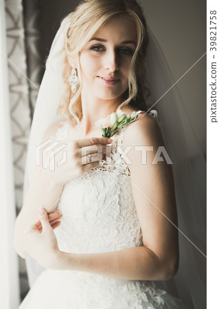 Luxury bride in white dress posing while preparing Luxury bride in white dress posing while preparing 39821758