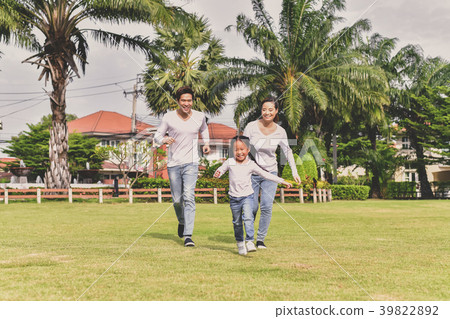 Parents and daughters go for a walk in the park. 39822892