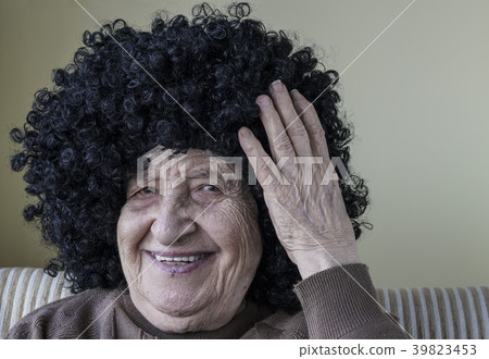 funny senior woman wearing curly black wig 39823453