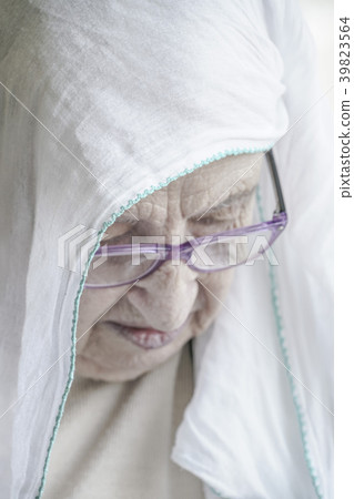 senior woman wearing headscarf while praying senior woman wearing headscarf while praying 39823564
