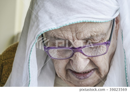 senior woman wearing headscarf while praying 39823569