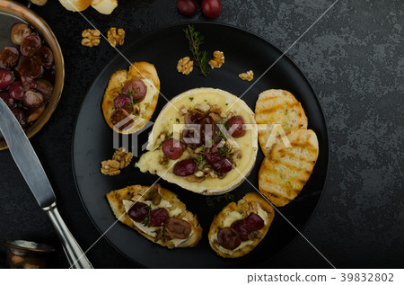 Brie cheese baked with nuts and grapes 39832802