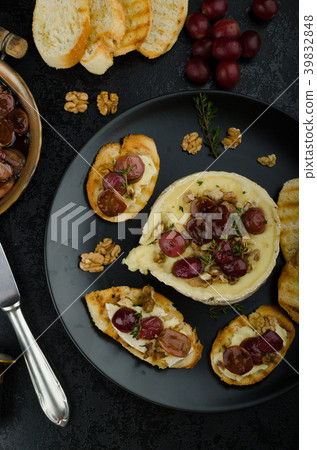 Brie cheese baked with nuts and grapes Brie cheese baked with nuts and grapes 39832848