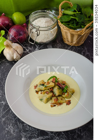 Spinach gnocchi with parmesan sauce topped with bacon 39834034