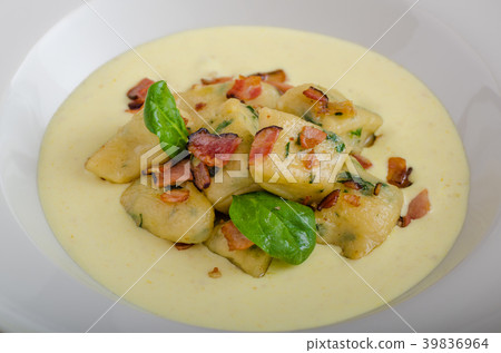 Spinach gnocchi with parmesan sauce topped with bacon 39836964