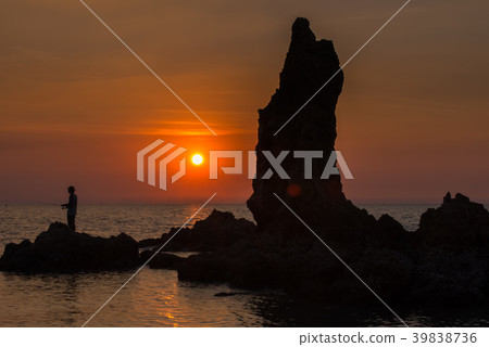 Fishermen standing on the rocks at sunset 39838736