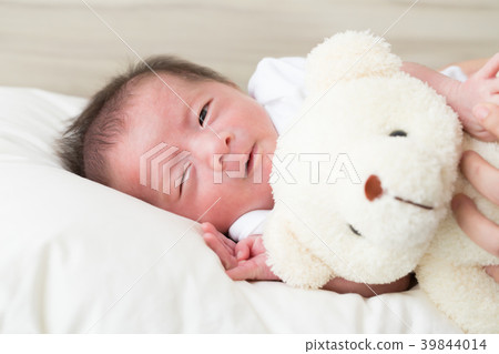Hug teddy and sleeping newborn baby boy on a bed 39844014