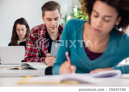 Student smiling while using a tablet during class Student smiling while using a tablet during class 39845596