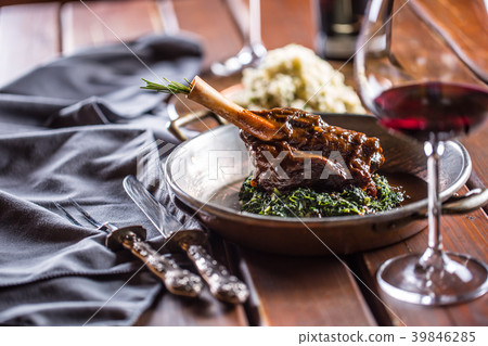 Roasted or confit Lamb Leg in pan with spinach. Roasted or confit Lamb Leg in pan with spinach. 39846285