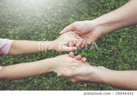 Mom and her daughter holding each other's hand.  V 39846442