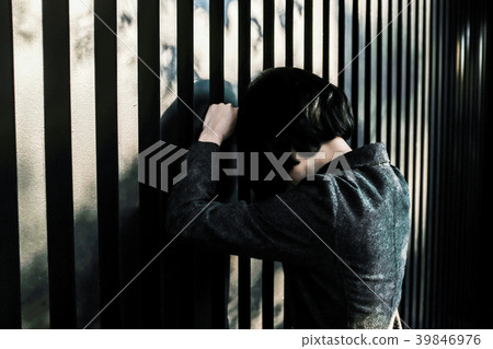Business woman leaning against fence Business woman leaning against fence 39846976