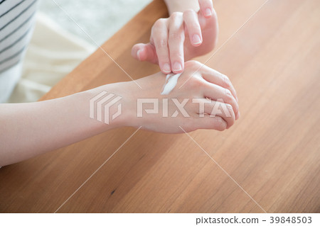 Hand of young woman applying hand cream 39848503