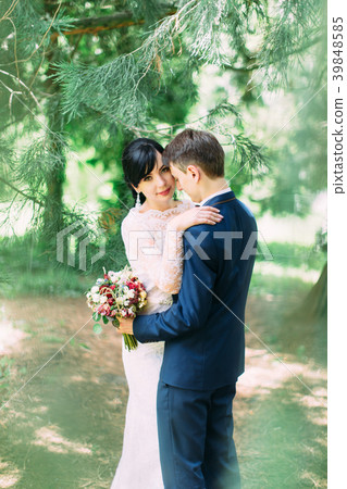 The back view of the groom hugged by the smiling The back view of the groom hugged by the smiling 39848585