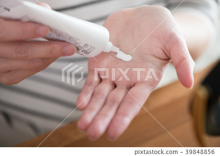 採取遮光劑奶油的少婦手中 採取遮光劑奶油的少婦手中 39848856