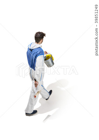 Young male decorator painting with a paint roller 39851249