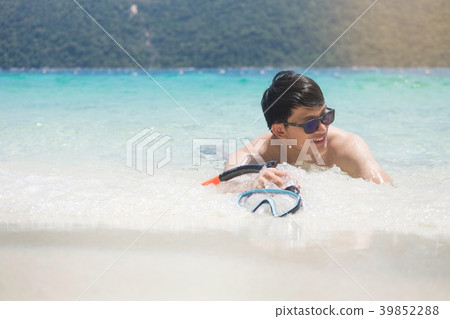 Man relaxing on the beach in vacations with sunset and blue sky Man relaxing on the beach in vacations with sunset and blue sky 39852288
