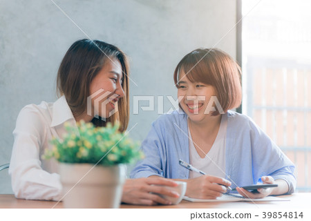 Two young business women sitting at table in cafe. 39854814