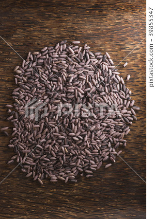 Dark purple rice on dark wooden background 39855347